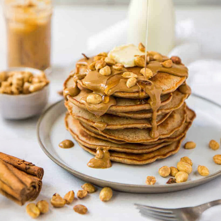 Stack of peanut butter pancakes with banana and drizzle